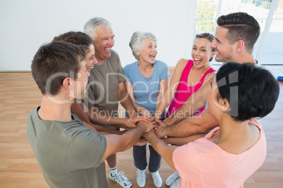 Portrait of happy sporty people holding hands together