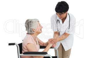 Female doctor talking to a senior patient in wheelchair