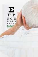 Rear view of a senior man looking at eye chart