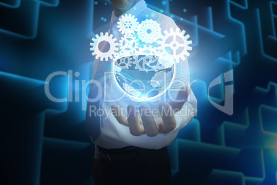 Businessman presenting earth with cogs and wheels