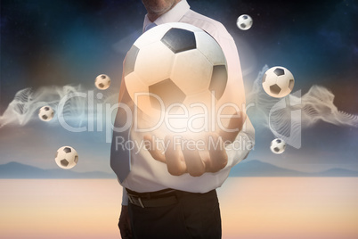 Businessman presenting floating footballs