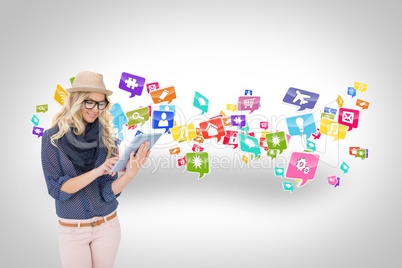 Stylish blonde using tablet pc with app icons