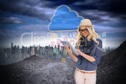 Stylish blonde using tablet pc with app icons and cloud