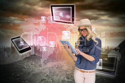 Stylish blonde using tablet pc with connecting devices