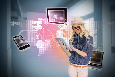 Stylish blonde using tablet pc with connecting devices