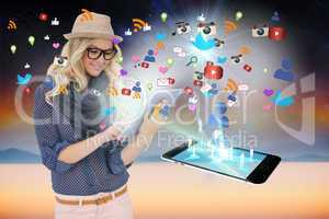 Stylish blonde using tablet pc with app icons and smartphone