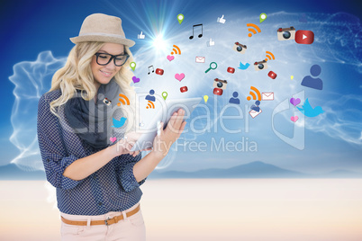 Stylish blonde using tablet pc with app icons