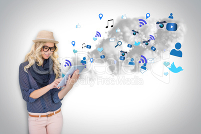 Stylish blonde using tablet pc with app icons and cloud