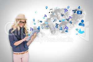 Stylish blonde using tablet pc with app icons and cloud