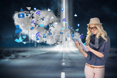 Stylish blonde using tablet pc with app icons and cloud