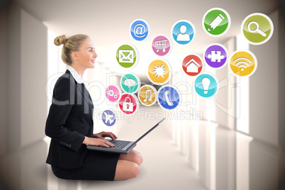 Blonde businesswoman sitting using laptop with app icons