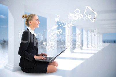 Blonde businesswoman sitting using laptop with cogs and wheels