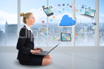 Blonde businesswoman sitting using laptop with cloud and app ico
