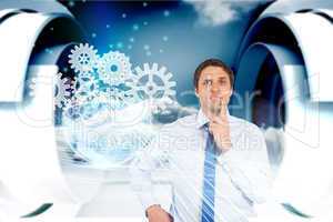 Confused businessman with cogs and wheels graphics