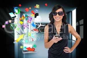 Glamorous brunette using smartphone with app icons and laptop