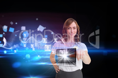 Smiling businesswoman pointing to laptop and profiles behind