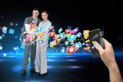 Hand holding smartphone with app icons and business partners beh