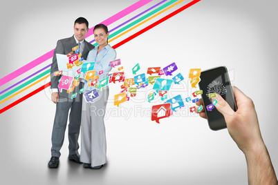 Hand holding smartphone with app icons and business partners beh
