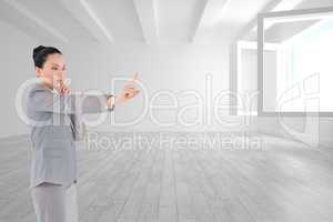 Composite image of thoughtful asian businesswoman pointing