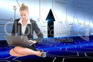 Composite image of businesswoman using laptop