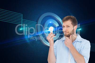 Composite image of handsome model holding a bulb