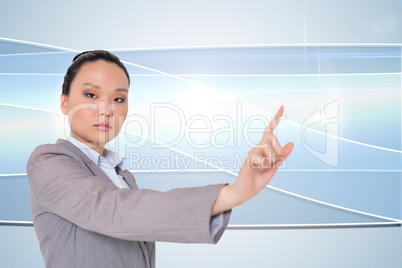 Composite image of unsmiling asian businesswoman pointing