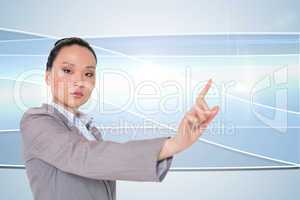 Composite image of unsmiling asian businesswoman pointing