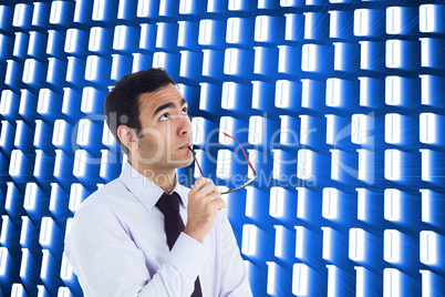 Composite image of thinking businessman holding glasses