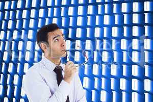 Composite image of thinking businessman holding glasses