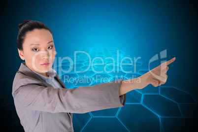 Composite image of unsmiling asian businesswoman pointing