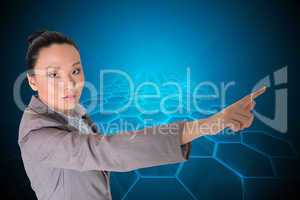 Composite image of unsmiling asian businesswoman pointing