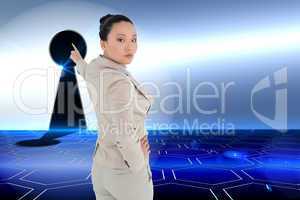 Composite image of unsmiling asian businesswoman pointing