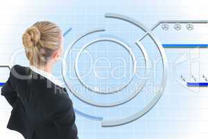 Composite image of businesswoman standing with hands on hips