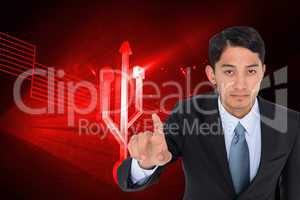 Composite image of serious asian businessman pointing