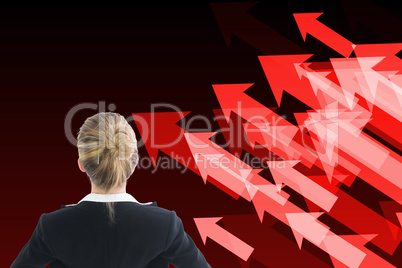 Composite image of businesswoman standing with hands on hips