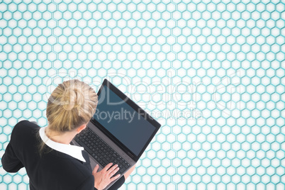 Composite image of businesswoman using laptop