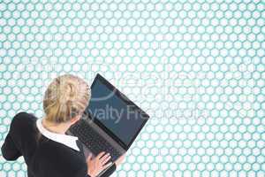 Composite image of businesswoman using laptop