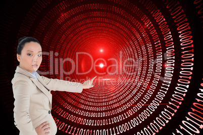 Composite image of unsmiling asian businesswoman pointing