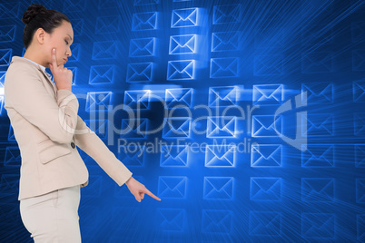 Composite image of thoughtful asian businesswoman pointing