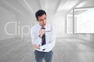 Composite image of thinking businessman holding glasses