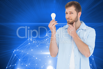 Composite image of handsome model holding a bulb