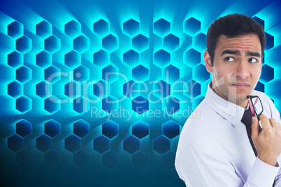 Composite image of thinking businessman holding glasses Composite image of thinking businessman holding glasses