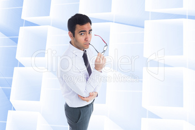 Composite image of unsmiling businessman holding glasses