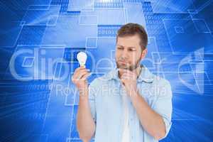 Composite image of sceptical model holding a bulb