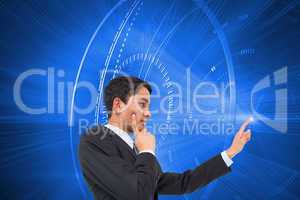 Composite image of thoughtful asian businessman pointing