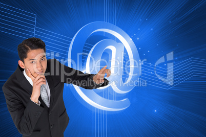 Composite image of thoughtful asian businessman pointing