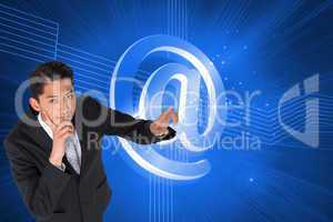 Composite image of thoughtful asian businessman pointing