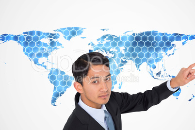 Composite image of unsmiling asian businessman pointing