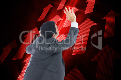 Composite image of businessman with arms raised