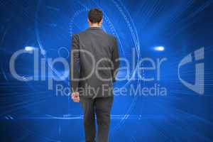 Composite image of young businessman walking away from camera